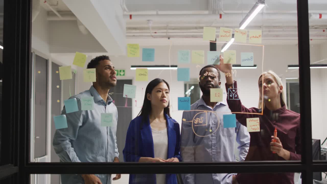video de cuatro colegas masculinos y femeninos diferentes intercambiando ideas juntos por la noche en la oficina