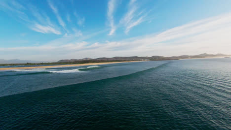 fpv drone flying close to seawater of mexican baja california with city view in the background