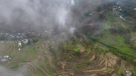 aerial drone shot of sunrays filtering through clouds over lush mountain slopes.