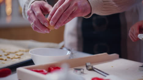 man cracks a raw egg into a bowl while preparing dough