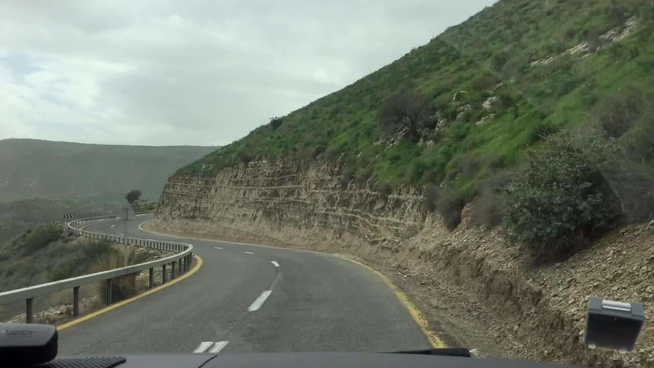 Conduciendo por una carretera de montaña sinuosa a través de verdes colinas