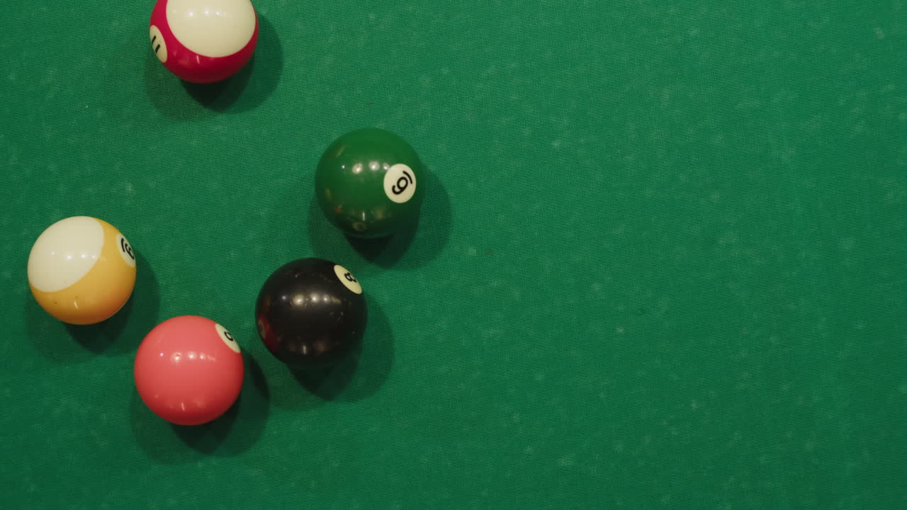 Breaking colorful pool balls top view on green billiards table for start to play. American pool, poule. Billiard balls with numbers on a pool table. Billiards team sport. High quality 4k footage