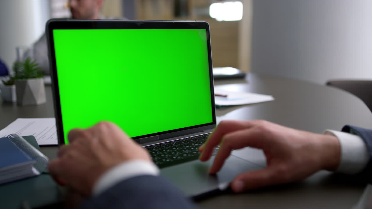 hombre de negocios usando pantalla verde de portátil táctil en la conferencia del equipo corporativo.