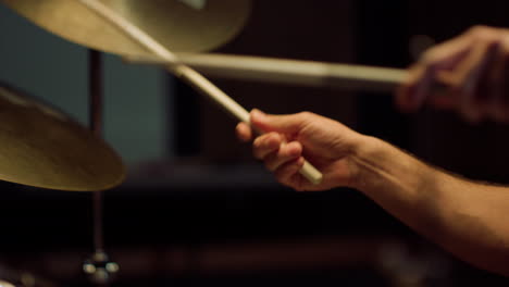 drummer rehearsing in studio. man hands holding drumsticks in concert hall.