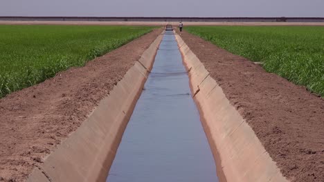 a farmer walks along the us mexico border with the wall in the background 1