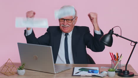 un riche homme d'affaires senior danse, célèbre, gagne, profite de la richesse, beaucoup d'argent, des dollars, de l'argent, la pluie tombe.