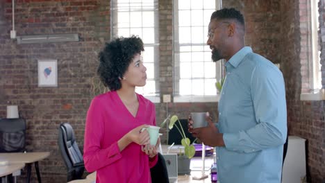 Happy-diverse-colleagues-talking-and-drinking-coffee-in-office-in-slow-motion