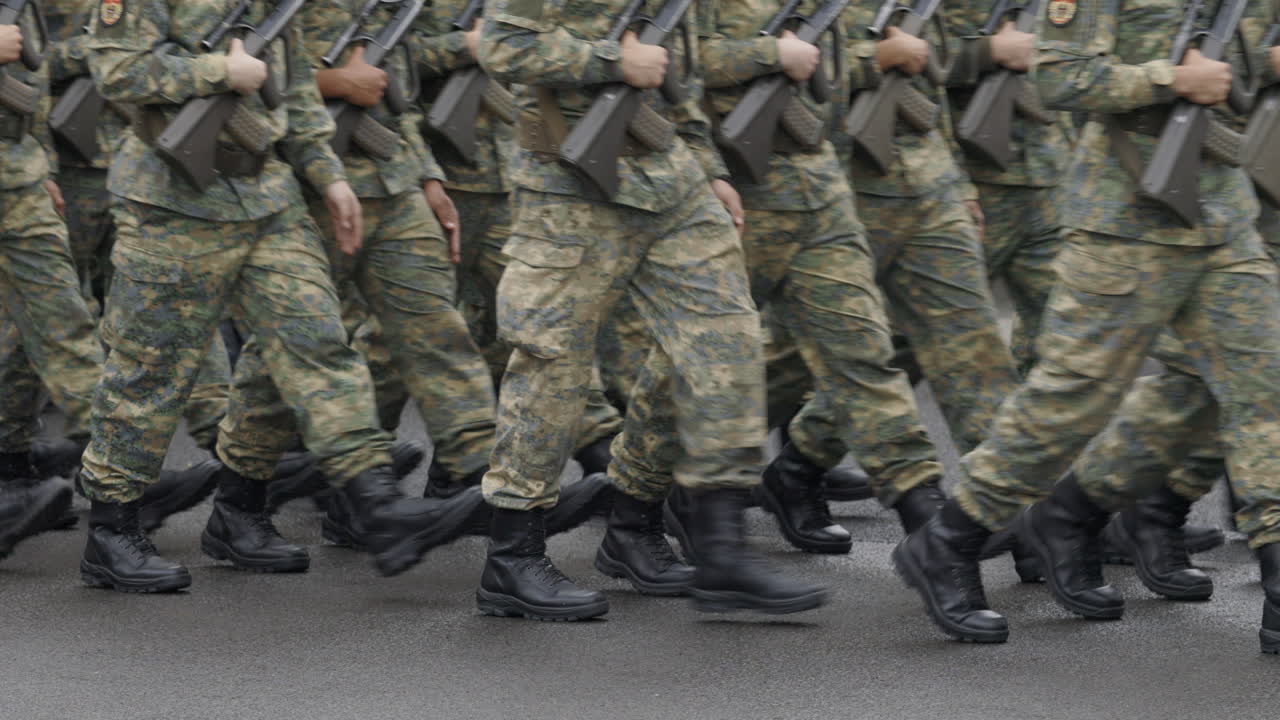 A group of soldiers in camouflage uniforms marching in formation