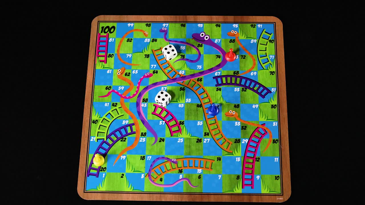 manos lanzando dados en el tablero de serpientes y escaleras