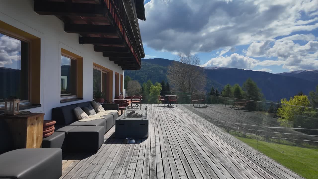Wooden deck with outdoor furniture overlooks Dolomite peaks in South Tyrol