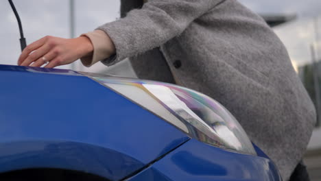 mujer comprobando un faro azul del coche