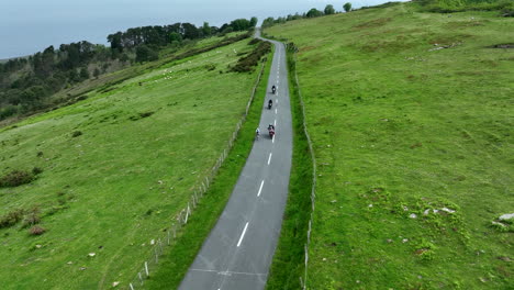 cinematic view of countryside road with motorbikes passing by, aerial