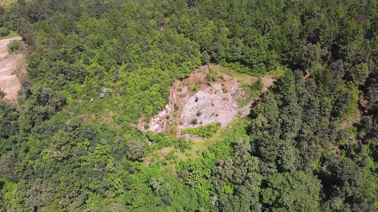 "vuelo orbital de drones sobre bosques exuberantes y excavaciones mineras"