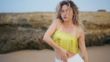 inspired woman dancing sand looking camera seductively close up. girl dancer