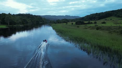 Speed-boat-driving-up-river-surrounded-by-lush-green-nature