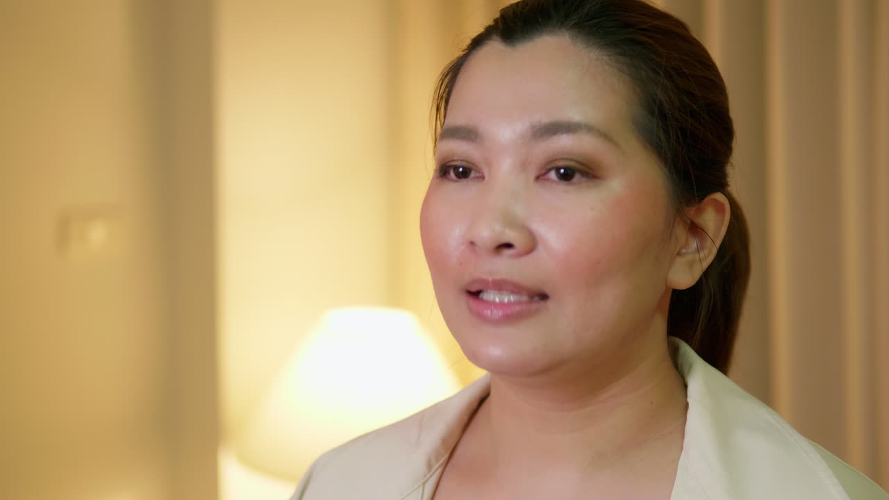 젊은 성인 여성이 평상복을 입고 방에서 말하는 비디오 온라인 커뮤니케이션을 설명하고 인터뷰합니다.