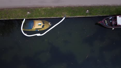 Locked-area-in-water-showing-sinking-motorboat-beside-docking-inland-vessel-at-port