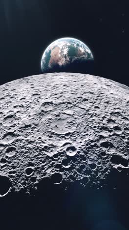 vertical shot of the far side of the moon as planet earth rises from behind and comes into view