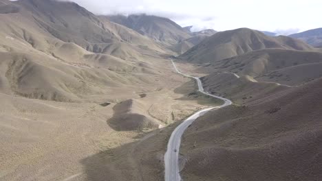 Cars-Driving-on-Road-Surrounded-by-Mountains