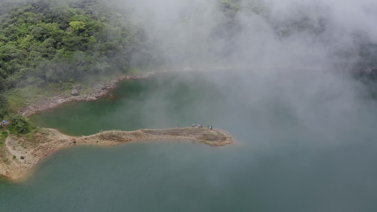오르모크, 레이테, 필리핀에서 안개가 자욱한 날 동안 다나오 호수의 암석 위에 서 있는 휴가객