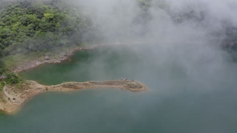 vacacionistas de pie sobre la formación rocosa en el lago danao durante el día brumoso en ormoc, leyte, filipinas