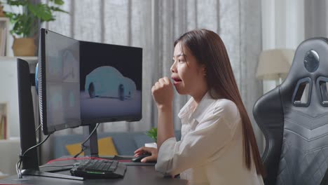 side view of asian female automotive designer yawning then sleeping while working on 3d model of ev car on the desktop computers in the studio