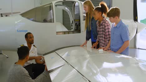 male pilot explaining about aeroplane to kids 4k