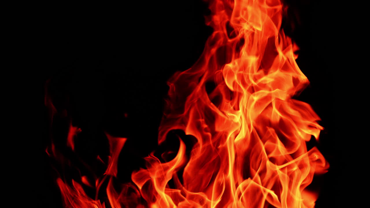 Toppen af det store bål bevæger sig i vinden. Nærbillede af flammen, der brænder om natten