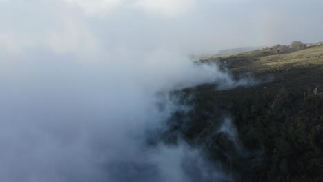 vista de drone sobre el volcán haleakala mientras las nubes blancas se mueven sobre la ladera de la montaña