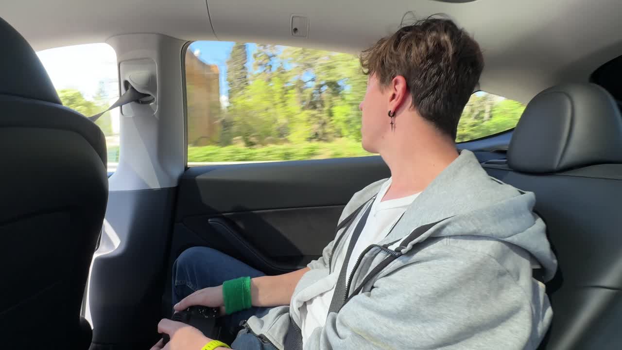 Teenager in the backseat of a Tesla
