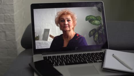 Happy-older-mature-60s-woman-indoor-head-shot-portrait.-Cheerful-elder-lady-wearing-eye-glasses,-casual,-looking-at-camera-with-toothy-smile,-posing-at-home,-laughing.-Video-call-screen