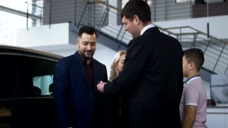 happy family getting new car in salon