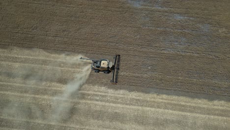 tractor harvesting grain. aerial tilt-down forward