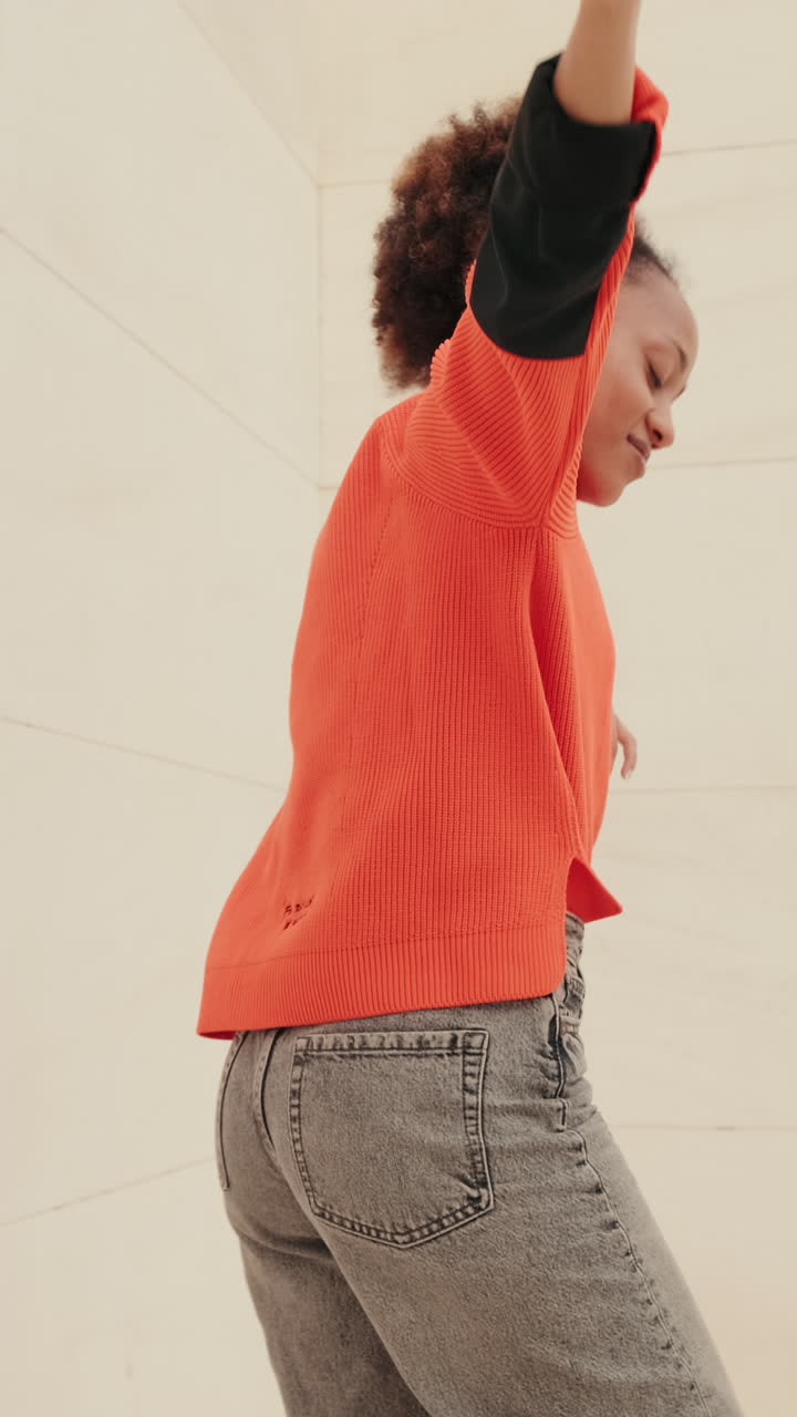 Young Woman Dances Joyfully in Minimalist Setting