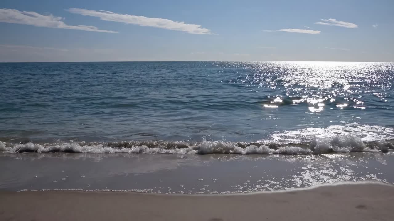 Tranquil beach scene with gentle waves lapping the shore, captured from a low angle