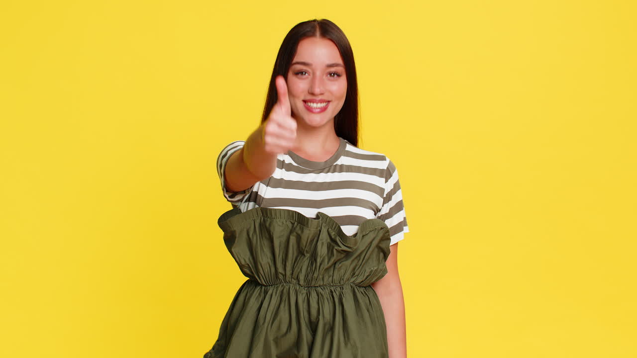 Woman smiling showing thumbs up gesture with confidence approval positivity happy emotional reaction