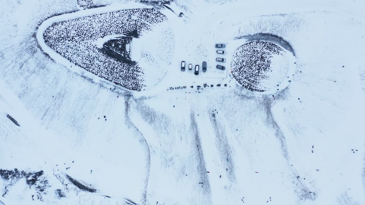 сверху вниз туристическая достопримечательность камбура зимой, люди катаются на санках с горки, аэрофотосъемка