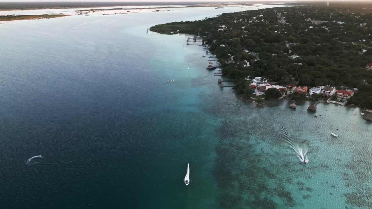 aerial de siete colores lago laguna en bacalar méxico drone vuela sobre el paisaje marino natural escénico y el resort de veleros ciudad de playa