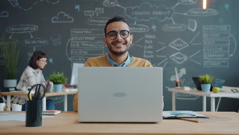 happy businessman working on laptop in modern office