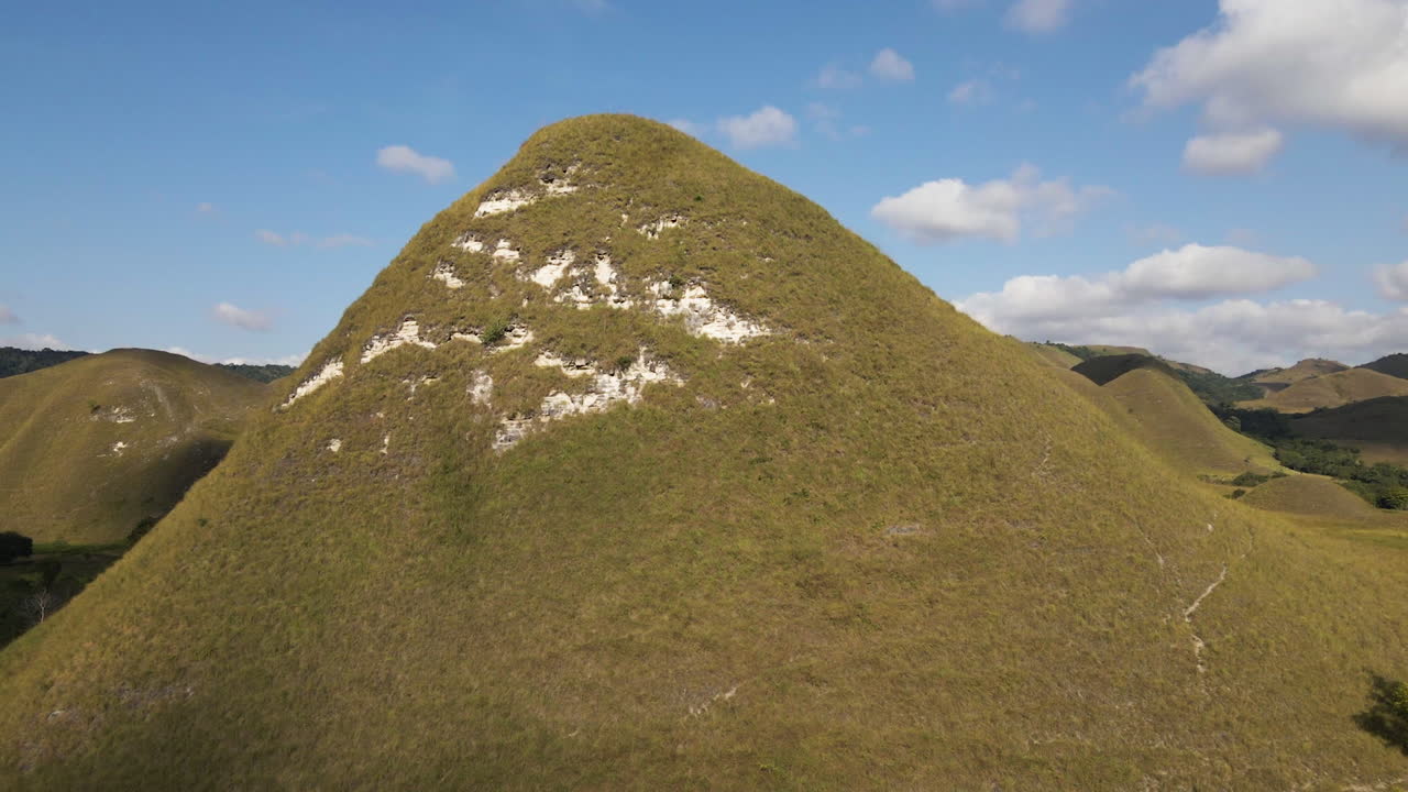 volando hacia la montaña verde en un día soleado de verano en la isla de sumba, indonesia