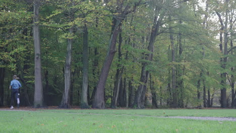 Toma-Estática-Que-Captura-A-Una-Mujer-Corriendo-Sobre-Un-Campo-De-Hierba-En-El-Parque