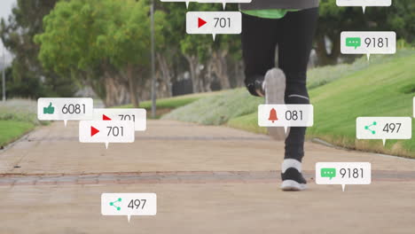 animation of notifications, low section of african american man with prosthetic leg jogging in park