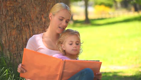 Young-mother-and-her-daughter-reading-a-book-together