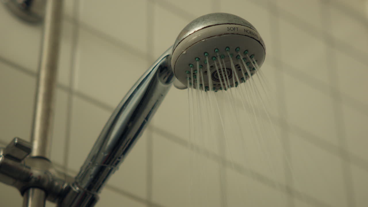 Close up of water being turned on and coming through the shower head