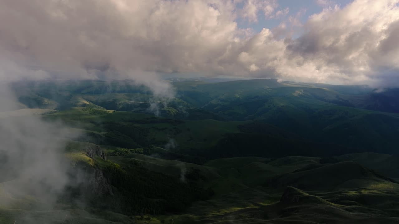 nubes bajas sobre una meseta montañosa en los rayos del atardecer. atardecer en la meseta de bermamyt norte del cáucaso, karachay-cherkessia, rusia.