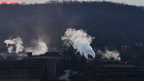 Destilería-De-Bourbon-En-Frankfort-Kentucky-Con-Grandes-Nubes-De-Humo-Sobre-Las-Casas-De-Madera-Durante-La-Puesta-De-Sol-En-La-Estática-Aérea-Del-Sendero-Del-Bourbon