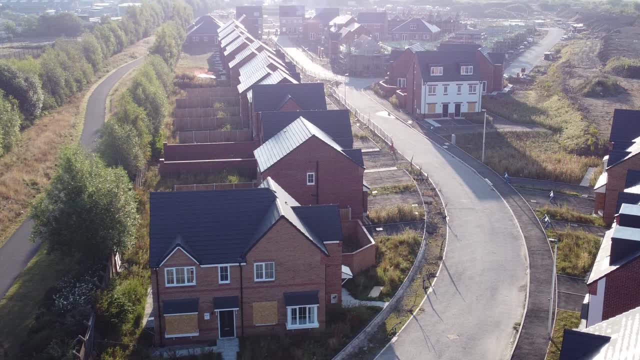 Luftfoto af morgensolopgang over tagene på et britisk forstadsbyggeri under opførelse