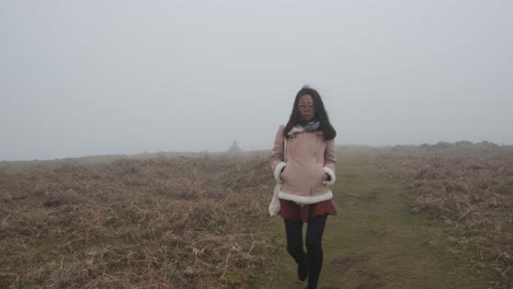 Still-shot-foggy-day,-asian-female-walking-on-Laurissilva-forest,-Madeira-Island