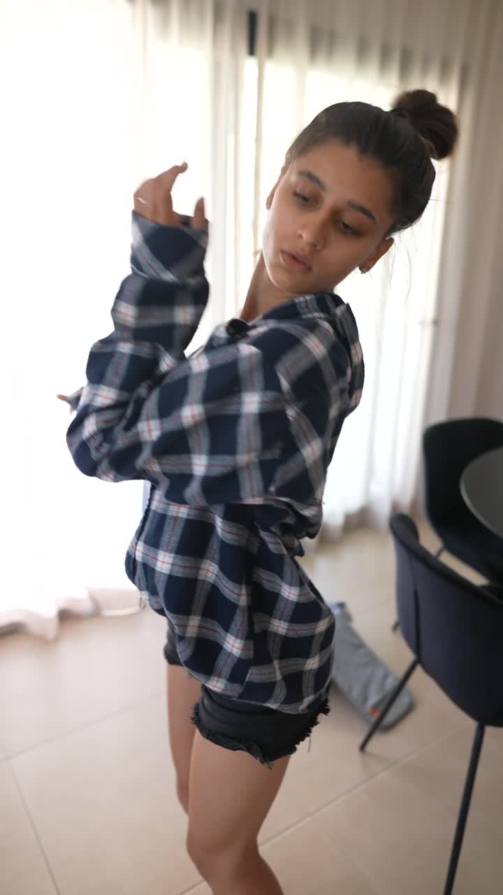 adolescente elegante con una camisa a cuadros y pantalones cortos de vaqueros