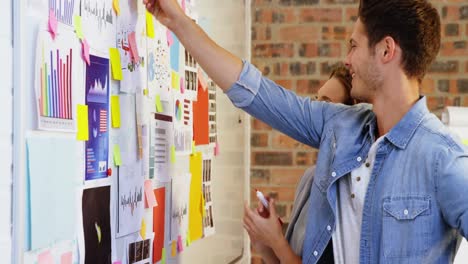 male and female business executive interacting over whiteboard